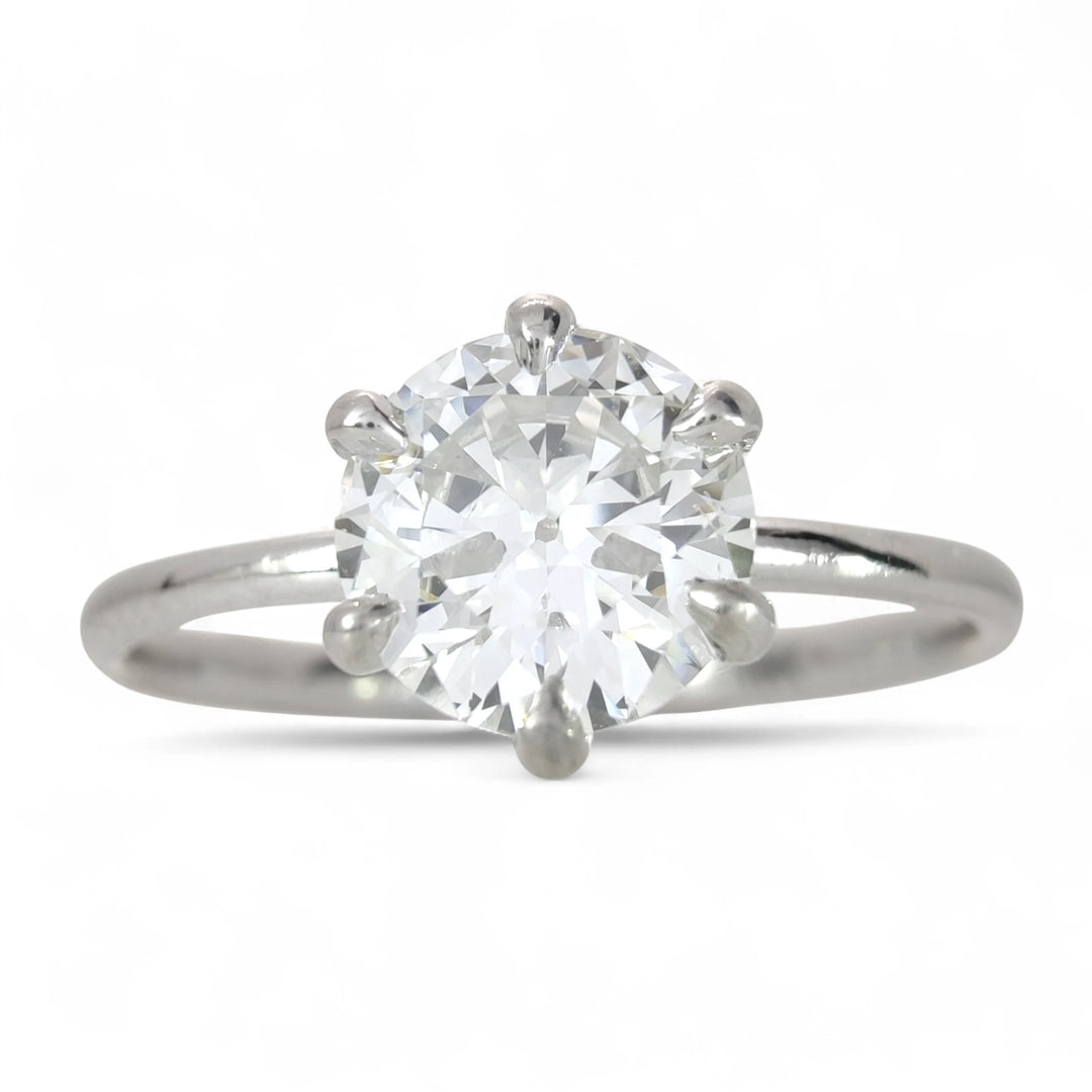 A sparkling 0.80-carat round brilliant diamond engagement ring with a sleek 18K white gold band, showcasing its fiery brilliance against a pure white backdrop