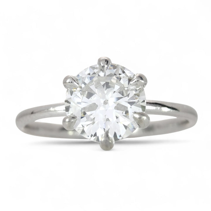 A sparkling 0.80-carat round brilliant diamond engagement ring with a sleek 18K white gold band, showcasing its fiery brilliance against a pure white backdrop