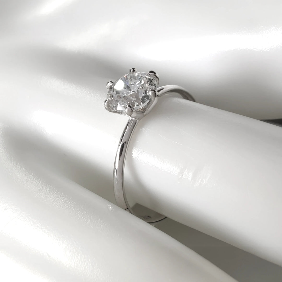 Front view of 0.90ct round brilliant diamond ring in 18k white gold, sparkling under natural light