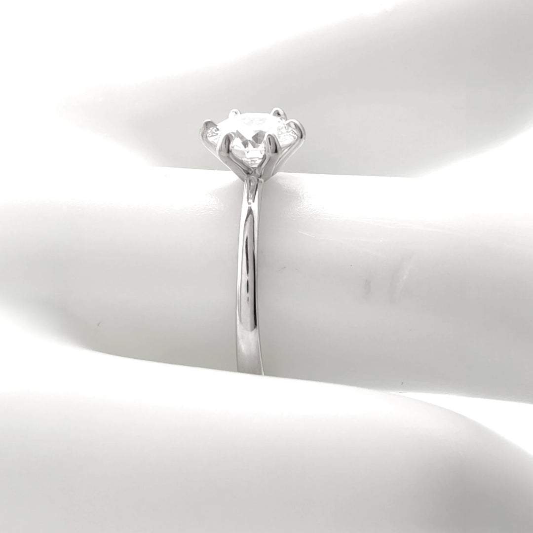 Detailed view of a secure four-prong diamond setting on an 18K white gold engagement ring, highlighting precise craftsmanship and polished metalwork