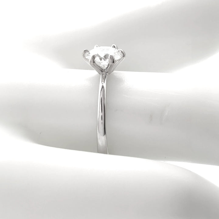 Detailed view of a secure four-prong diamond setting on an 18K white gold engagement ring, highlighting precise craftsmanship and polished metalwork