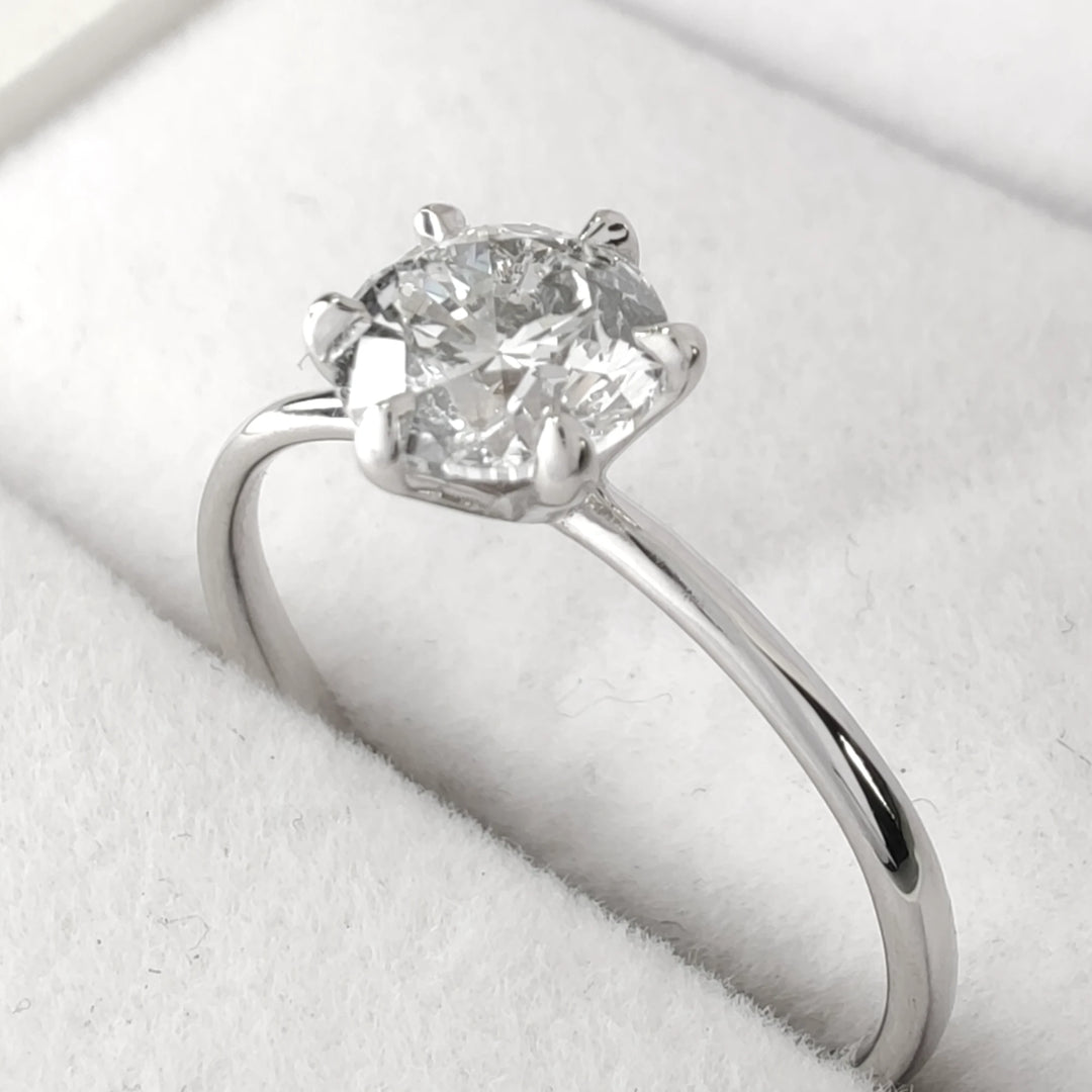 Side profile of handmade diamond ring showing six-prong setting and light reflection on 18k white gold band