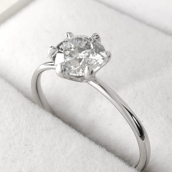Side profile of handmade diamond ring showing six-prong setting and light reflection on 18k white gold band