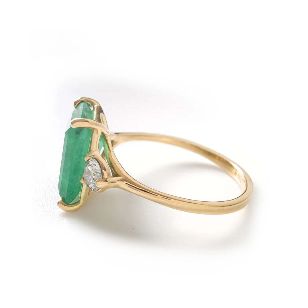 Left side view of emerald and diamond ring in 18K yellow gold with raised setting