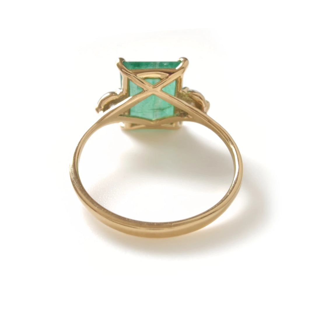 Back view of emerald engagement ring with diamonds in 18K gold