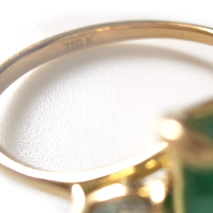 Close-up of 750 gold hallmark on the band of emerald and diamond ring