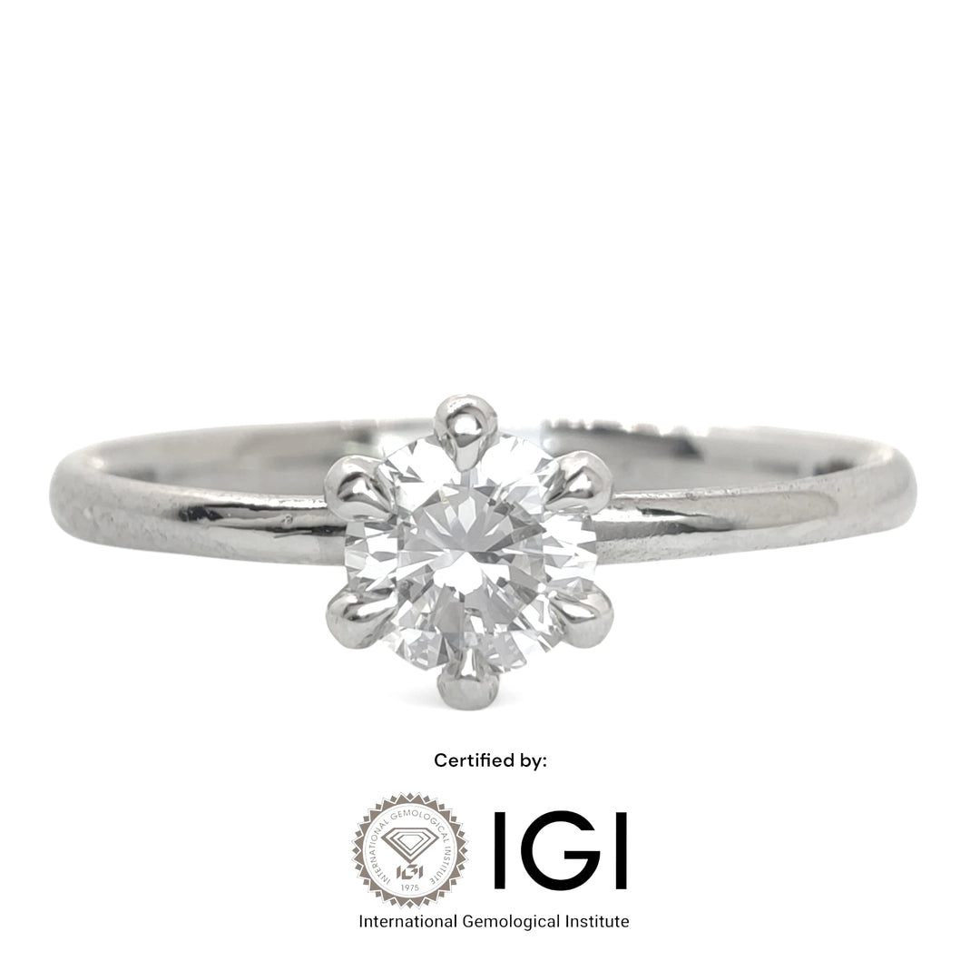 A classic six-prong solitaire engagement ring featuring a round brilliant-cut diamond set in polished platinum. The sleek band and secure prong setting highlight the stone’s brilliance against a minimalist white backdrop