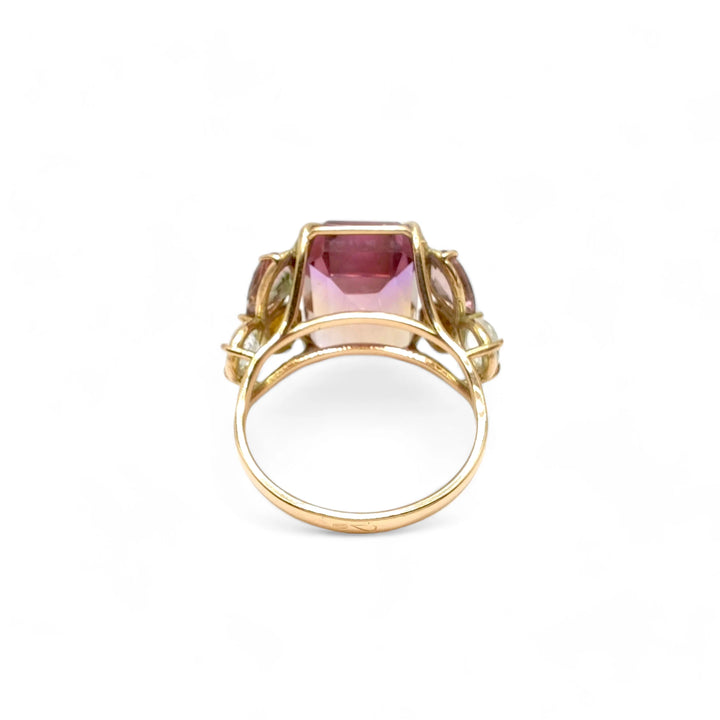 Back view of a handcrafted 14K yellow gold cocktail ring with an emerald-cut ametrine centerpiece, amethyst, and aquamarine accents