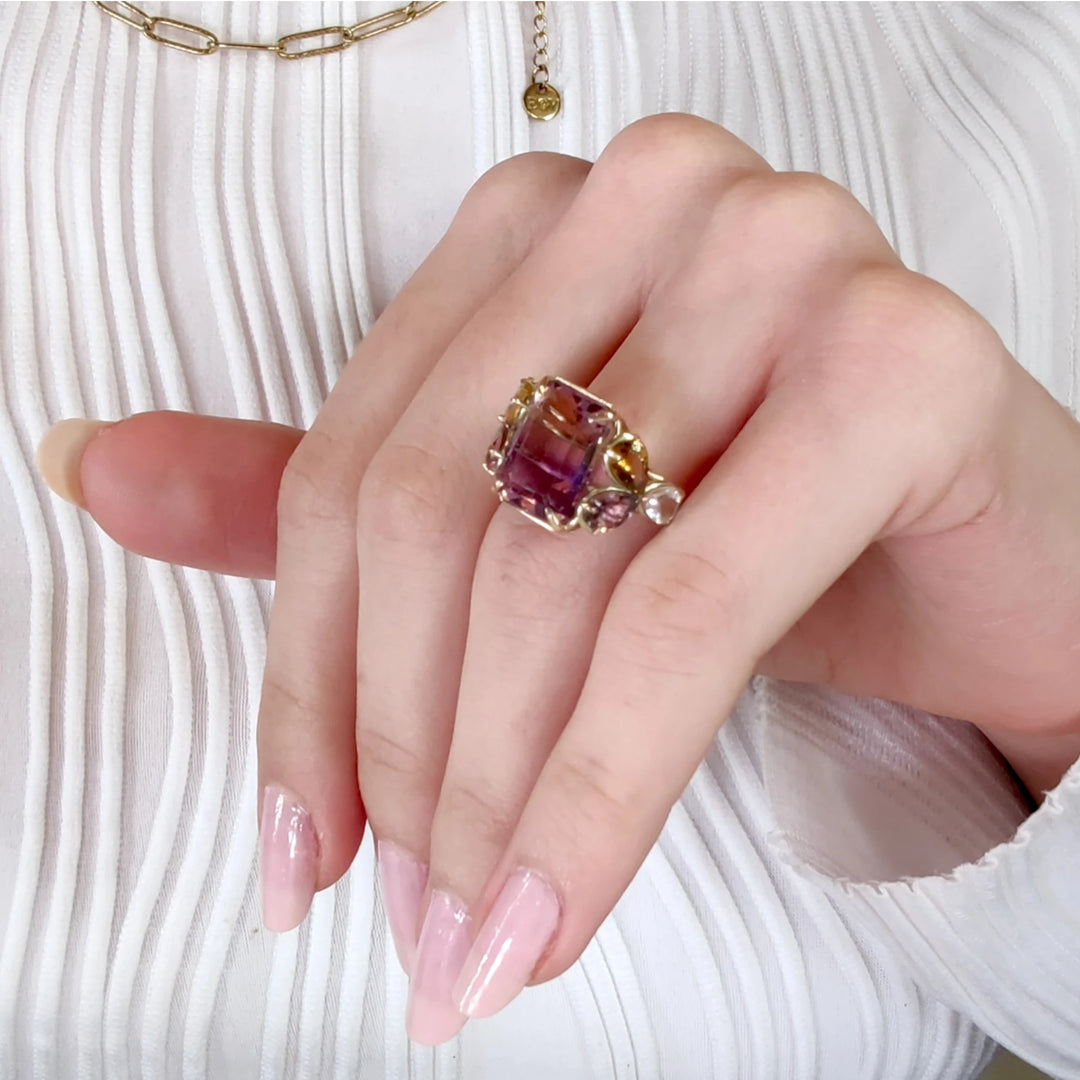 Elegant handcrafted 14K yellow gold ring with a unique combination of ametrine, amethysts, and aquamarines worn by a female model