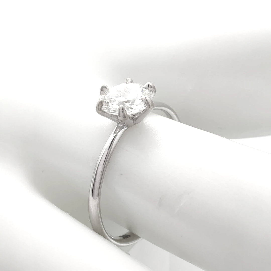 Timeless six-prong engagement ring with a round brilliant diamond, shown from the side to reveal its slender 18K white gold band and secure setting