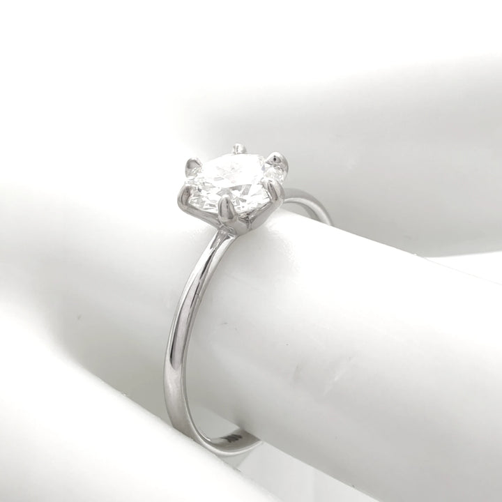 Timeless six-prong engagement ring with a round brilliant diamond, shown from the side to reveal its slender 18K white gold band and secure setting