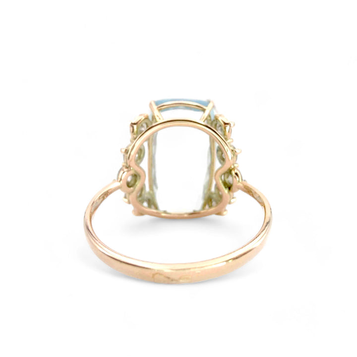 Back view of a handcrafted engagement ring in 14K yellow gold with a rectangular cushion aquamarine and diamond details
