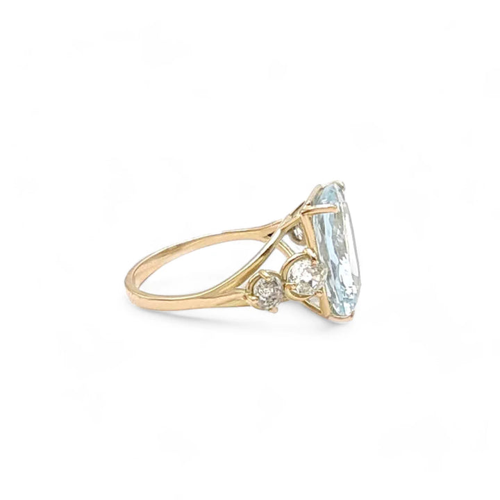 Right side view of a 14K yellow gold ring showcasing a cushion-cut aquamarine with diamond accents