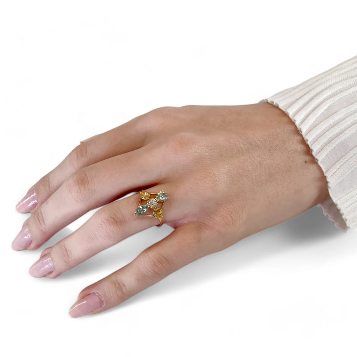 Complete hand view of a model wearing a 14K yellow gold engagement ring with a unique cross design of brilliant and fancy yellow marquise diamonds