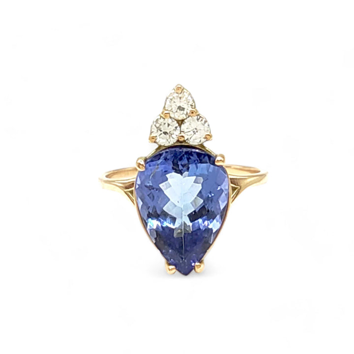 Front view of a 14K yellow gold engagement ring with a central pear-cut tanzanite and three sparkling diamonds, perfect for a Christmas or engagement gift