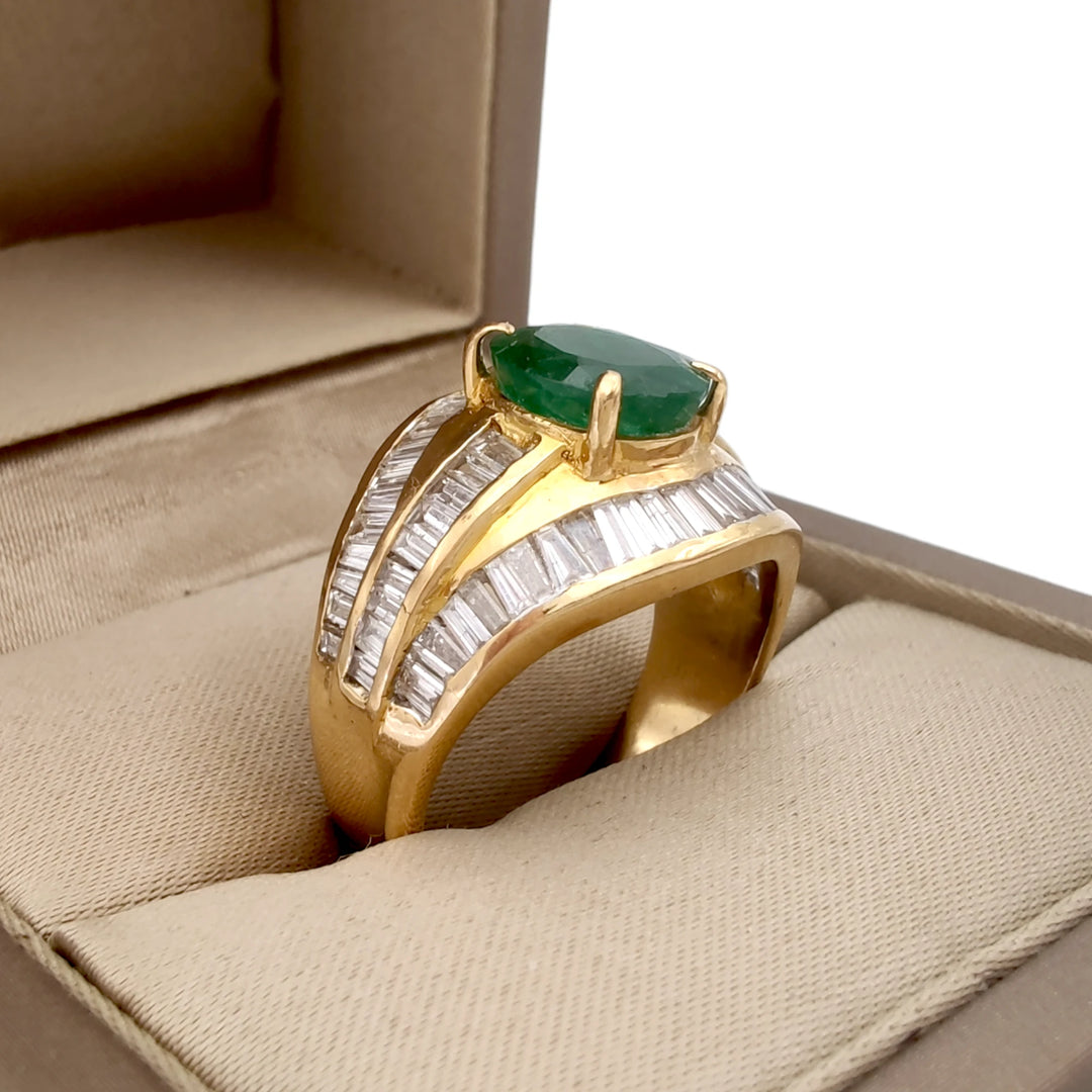 Elegant 22K gold cocktail ring with an oval emerald and diamond baguettes beautifully presented inside a jewelry box, ideal for gifting or special celebrations.