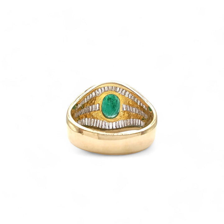 Back view of a 22K gold cocktail ring with an oval emerald center and diamond baguettes, displaying the meticulous setting and finish of the high-quality metals
