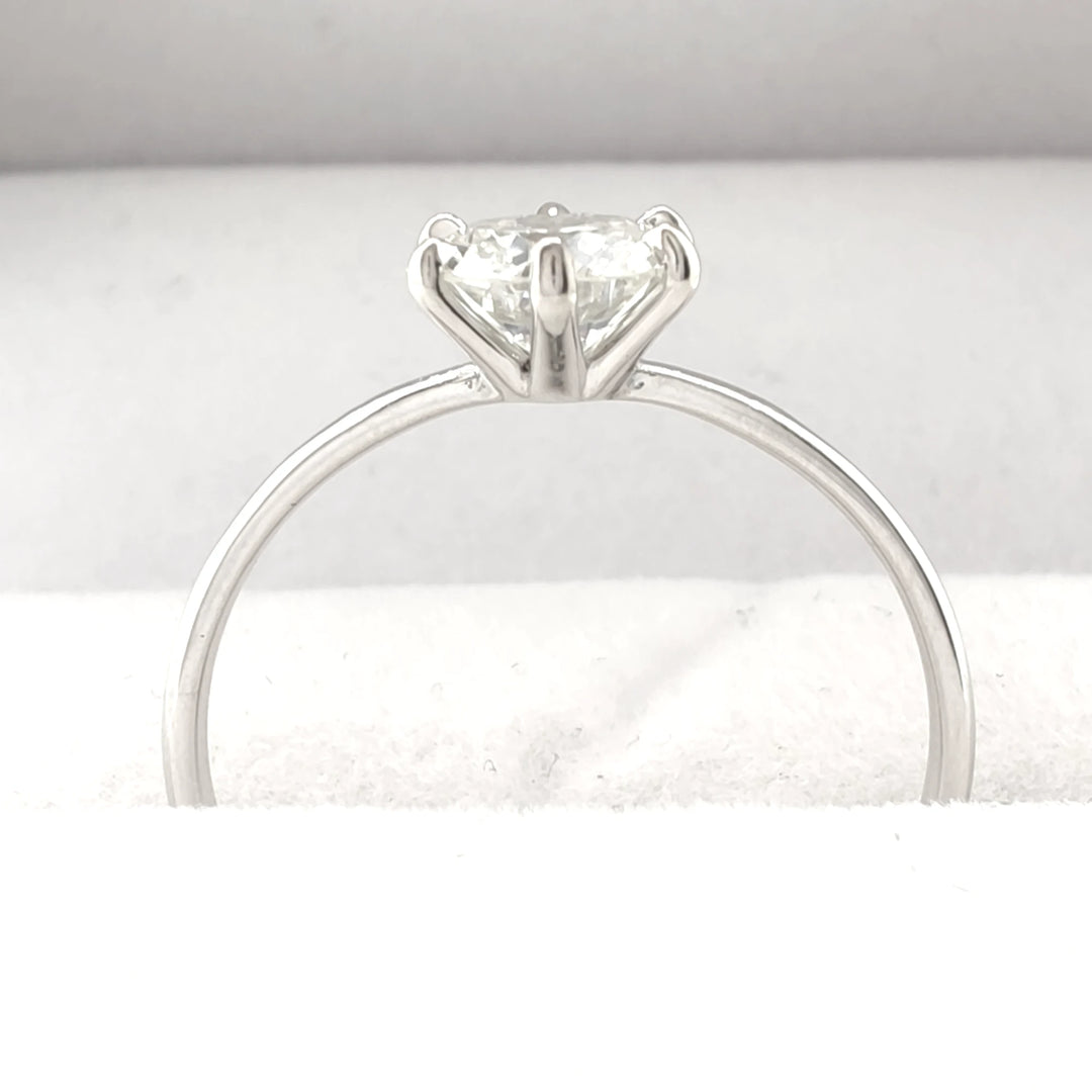 A stunning 18K white gold engagement ring featuring a 0.80-carat round brilliant-cut diamond with a secure four-prong setting, displayed on a plush white fabric backdrop