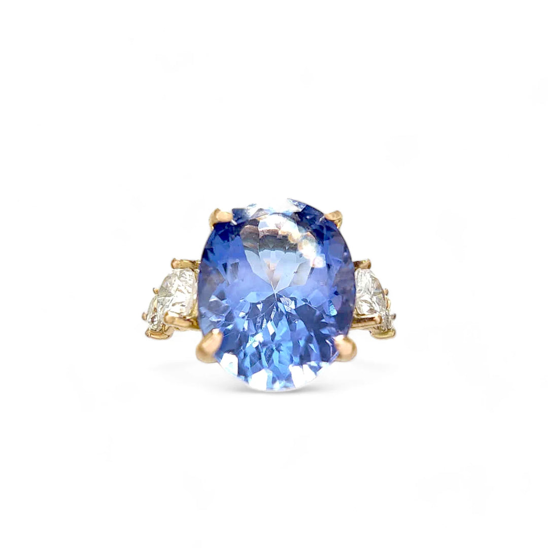 Front view of a women’s 14K yellow gold ring with an oval Tanzanite and brilliant-cut diamonds