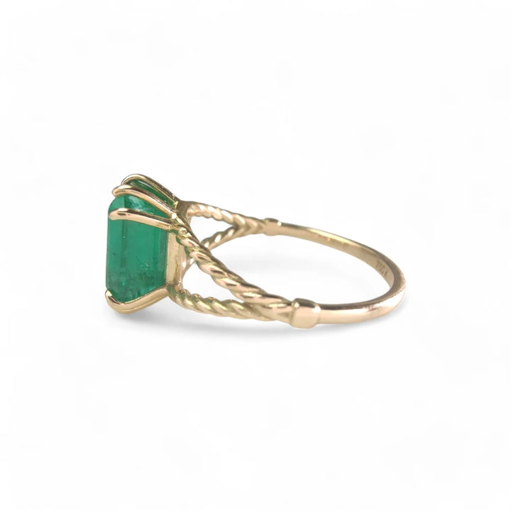 Left-side view of an 18K yellow gold emerald engagement ring, showcasing its octagonal green emerald centerpiece, ideal as a Christmas gift or engagement ring