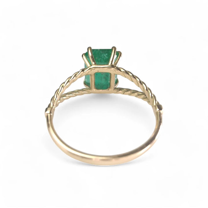 Rear view of an emerald engagement ring crafted in 18K yellow gold, with an octagonal green emerald centerpiece, a meaningful Christmas gift or engagement ring