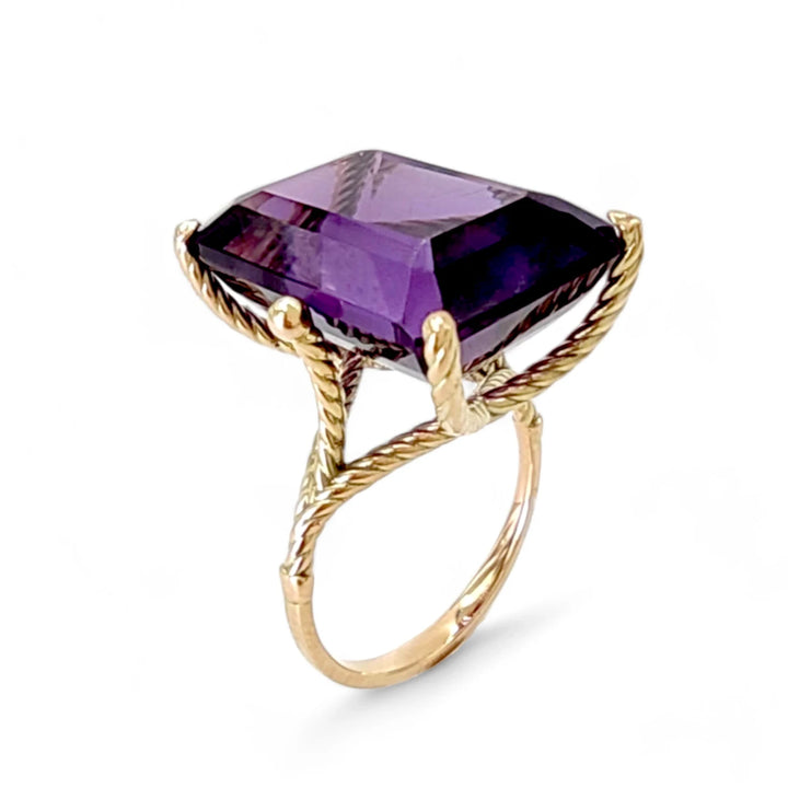 Vertical perspective view of a women’s 14K solid yellow gold ring featuring a large amethyst mounted in sculptural twisted prongs, perfect for those who love bold, unique designs