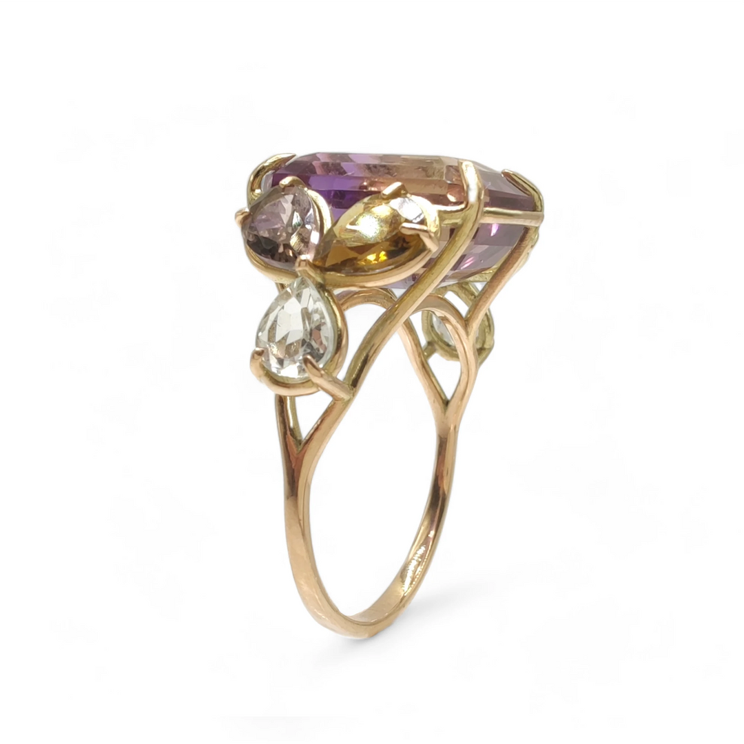 Vertical perspective view of a handcrafted 14K solid yellow gold cocktail ring featuring a central emerald-cut ametrine, two pear-shaped amethysts, and two pear-shaped aquamarines, a unique artistic design for women who value beauty