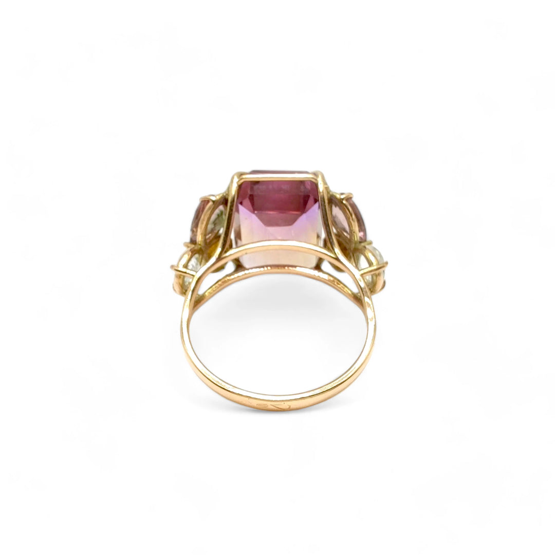 Back view of a handcrafted 14K yellow gold cocktail ring with an emerald-cut ametrine centerpiece, amethyst, and aquamarine accents