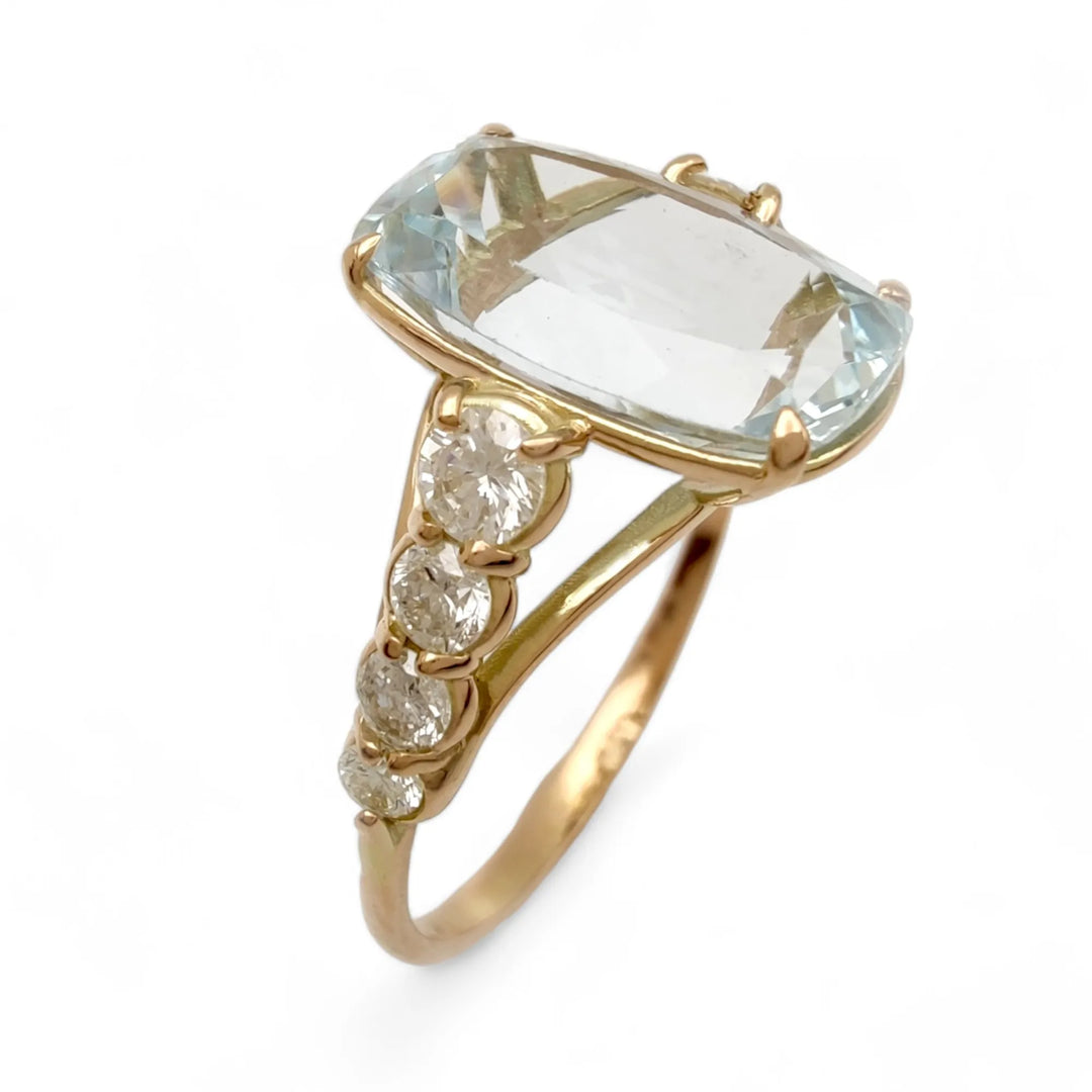 Vertical perspective view of a handcrafted 14K yellow gold ring featuring a cushion-cut aquamarine centerpiece and four round diamonds in a tapered design on each side, perfect as a unique engagement or cocktail ring