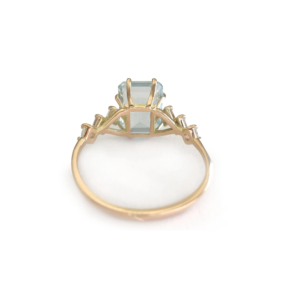 Back view of a bold handcrafted 14K yellow gold ring with a central aquamarine and diamond accents in a unique artistic design