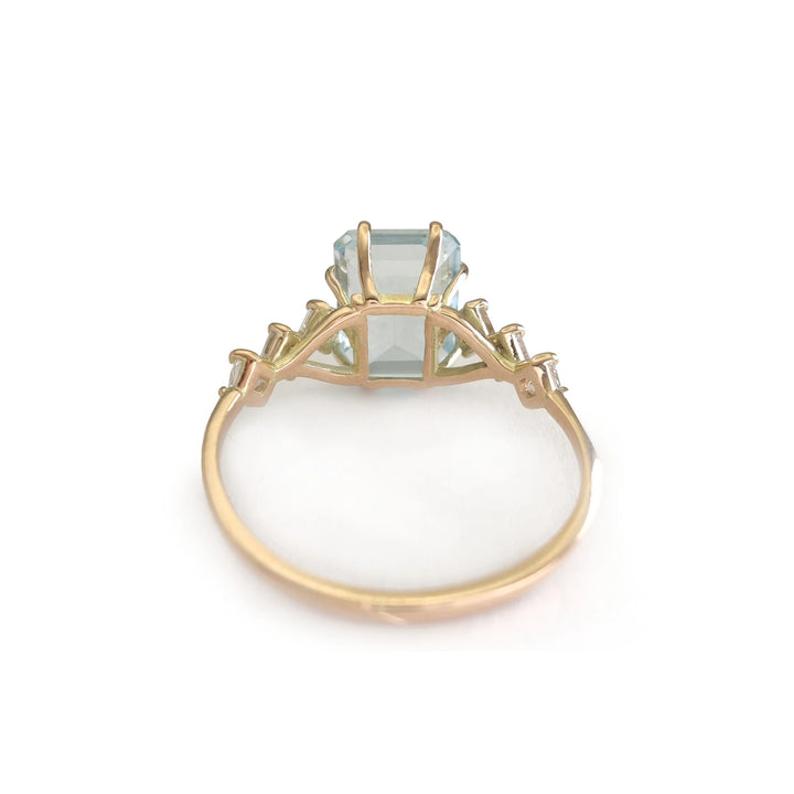 Back view of a bold handcrafted 14K yellow gold ring with a central aquamarine and diamond accents in a unique artistic design