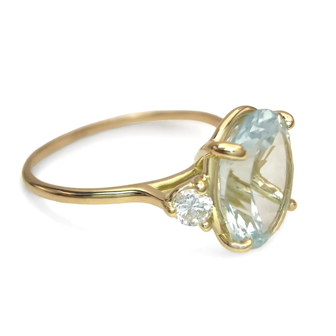 Escorzo view of a women’s 18K yellow gold engagement ring with aquamarine and diamonds