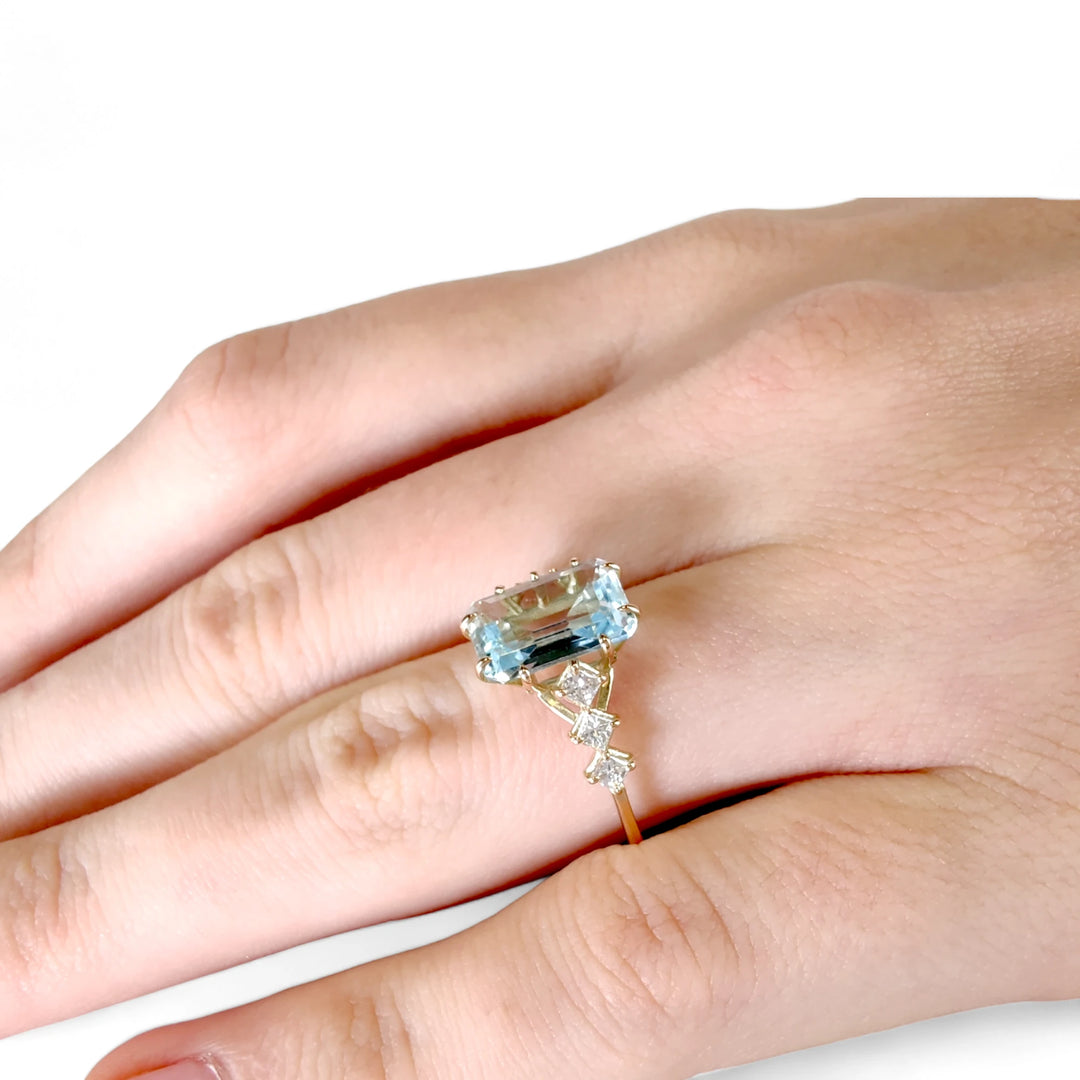 Stunning aquamarine and diamond ring in 14K yellow gold, worn on a female model’s hand, perfect for proposals, Christmas, or artistic jewelry lovers