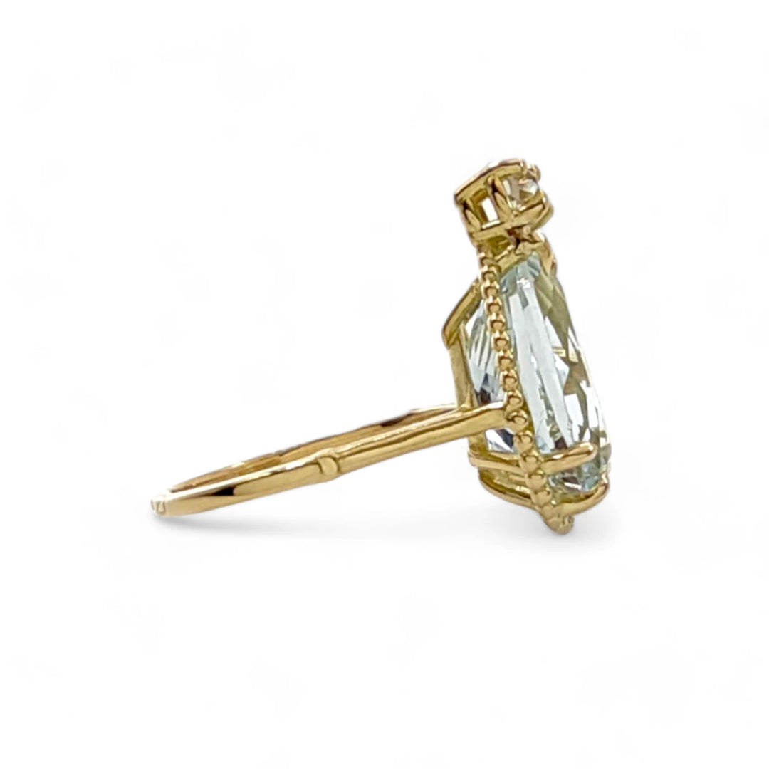 Right side view of a vintage 18K yellow gold engagement ring with a pear-cut aquamarine and a diamond