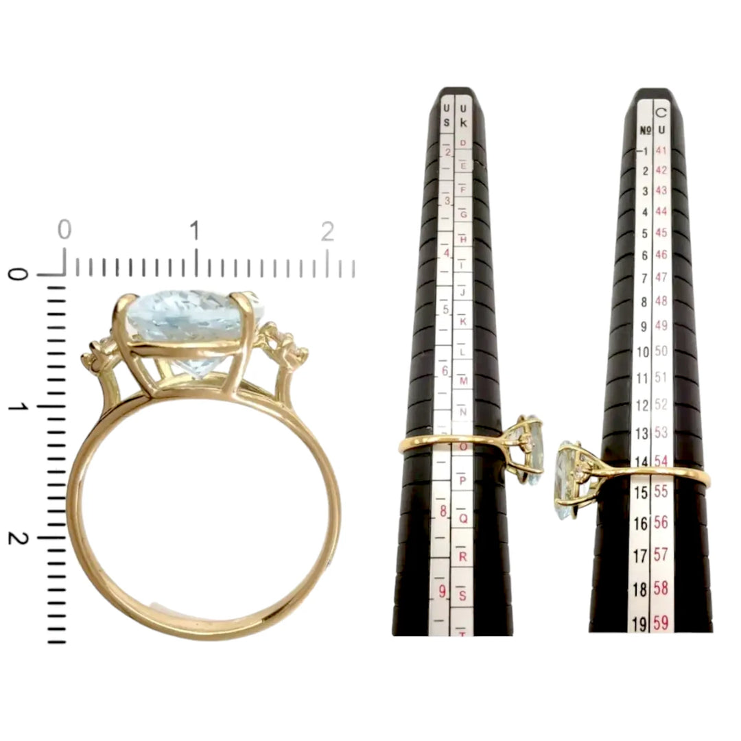 Measurement scale and size chart for a three-stone engagement ring in 18K yellow gold with an oval aquamarine and diamond accents