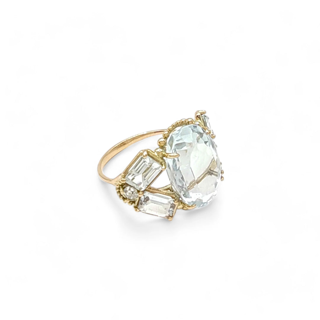 Horizontal right side view of a women’s vintage-style 14K yellow gold cocktail ring with aquamarine gemstones and diamond accents