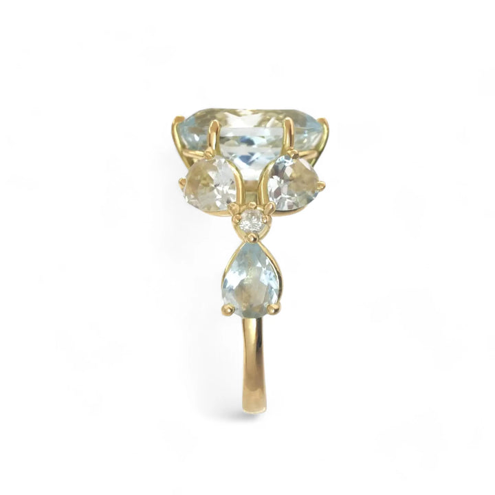 Vertical side view of a handcrafted ring featuring a central oval aquamarine, marquise aquamarines, and diamond floral accents