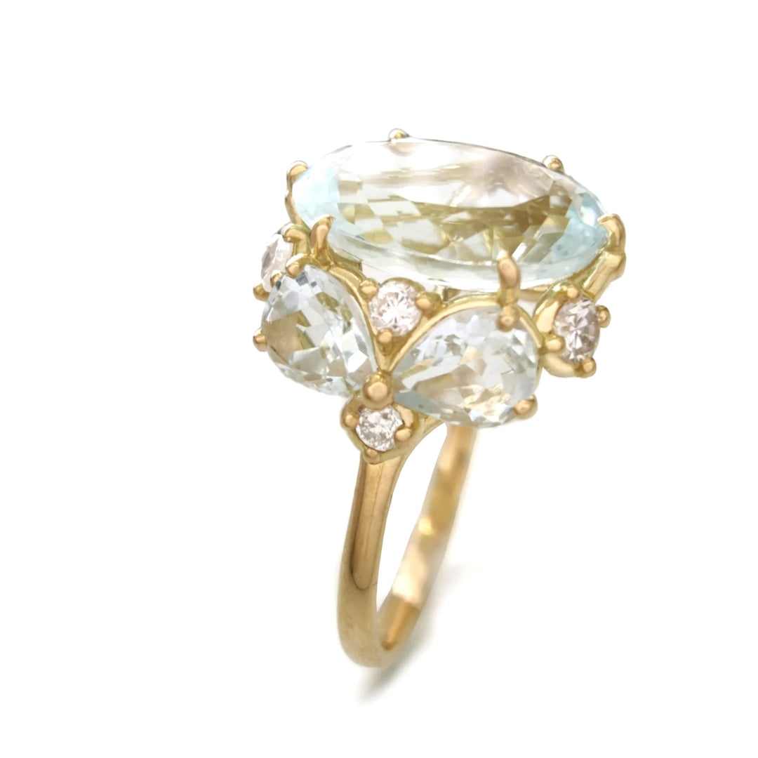 Vertical perspective view of an 18K yellow gold engagement ring featuring a central oval aquamarine flanked by four brilliant-cut diamonds and two pear-shaped aquamarines on each side, perfect for Christmas gifts