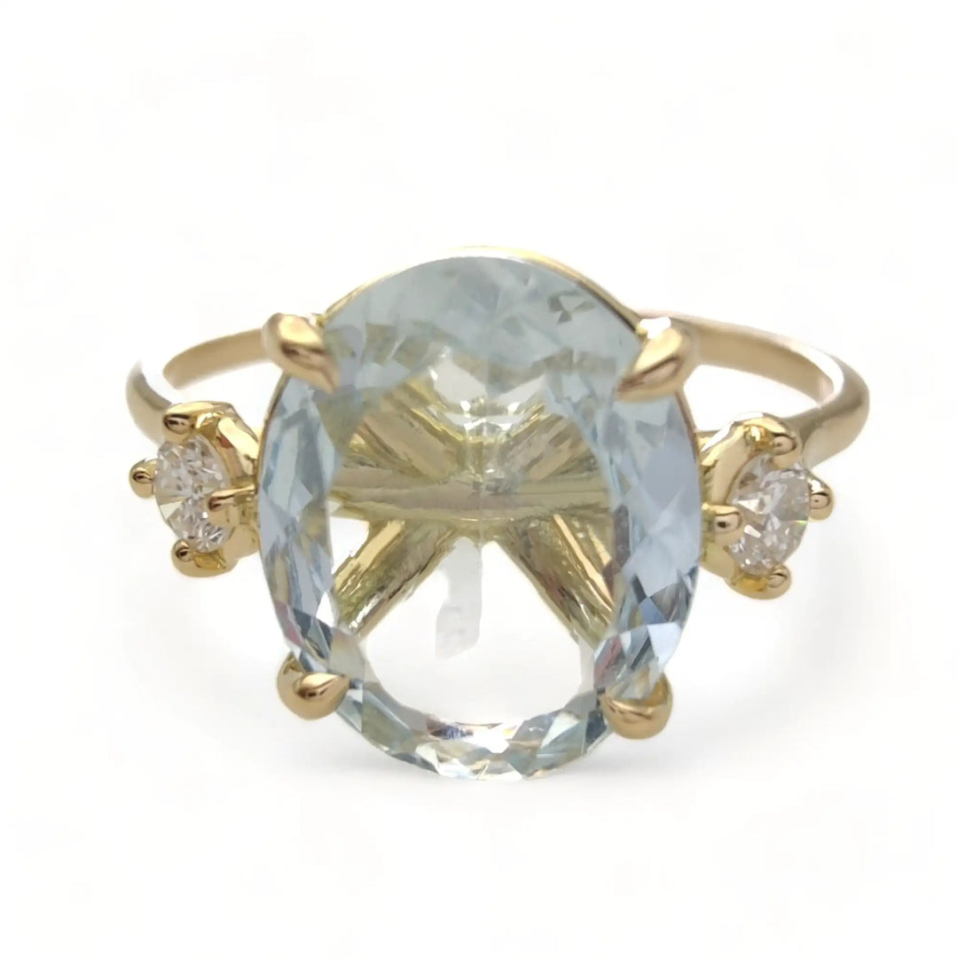 Front view of a buyable 18K yellow gold engagement ring featuring a central oval aquamarine flanked by brilliant diamonds, perfect as a Christmas or birthday gift