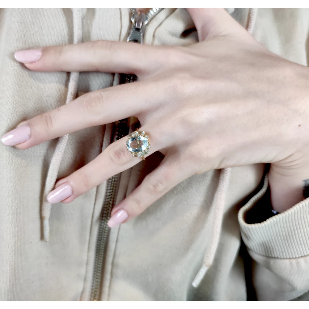 Full hand view of a model wearing a stunning 18K yellow gold engagement ring with aquamarines and diamonds, perfect for buyers looking for a statement piece