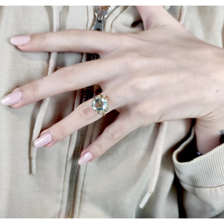 Full hand view of a model wearing a stunning 18K yellow gold engagement ring with aquamarines and diamonds, perfect for buyers looking for a statement piece