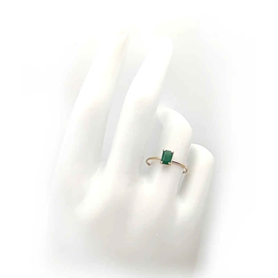 18K yellow gold solitaire emerald engagement ring displayed on a mannequin hand, showcasing its elegant design, perfect for Christmas or Black Friday gifting