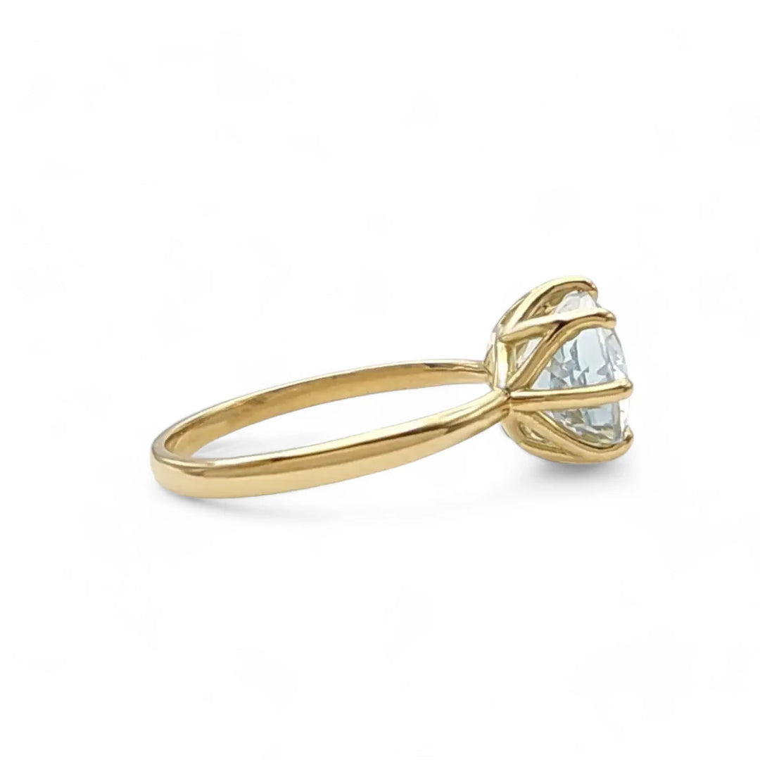 Left side view of an 18K yellow gold solitaire engagement ring with an oval aquamarine, perfect for those looking to buy a significant engagement ring.