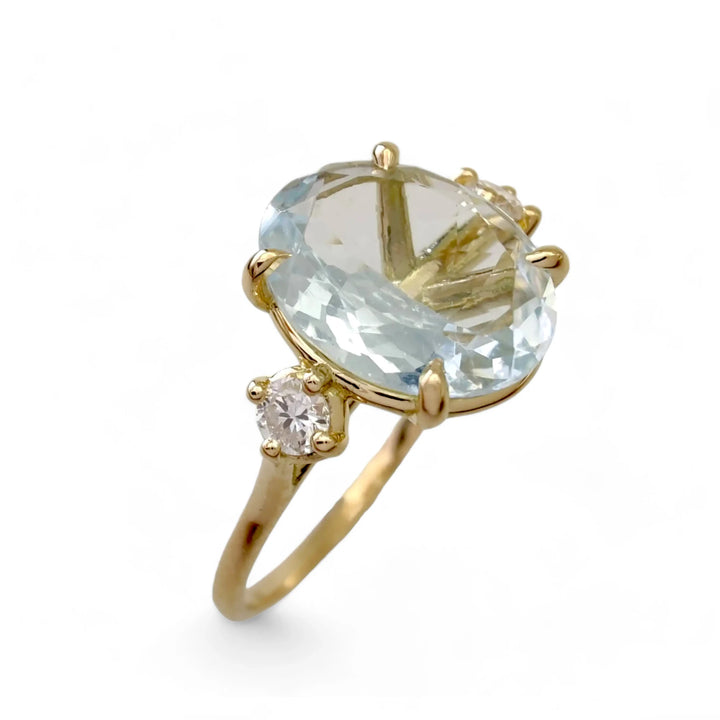 Buy this engagement ring: a vertical view of a 18K yellow gold trinity ring featuring a central oval aquamarine and two brilliant-cut diamonds, perfect as a Christmas gift