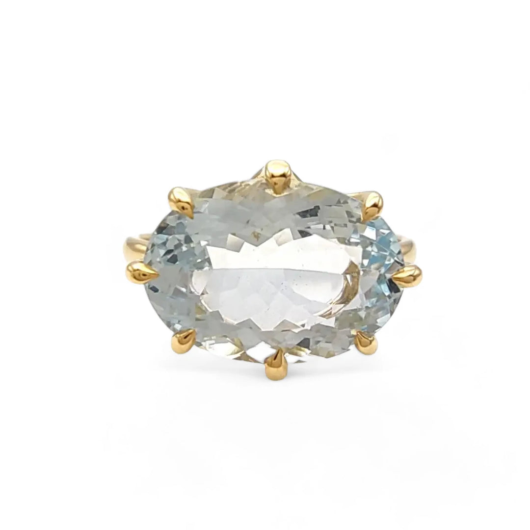 Front view of an 18K yellow gold solitaire engagement ring with an oval aquamarine, highlighting the ring's suitability for engagement and special moments