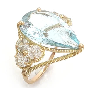 Vertical view of a 14K yellow gold engagement ring featuring a large pear-cut aquamarine center and three diamonds on each side, perfect for a special Christmas gift or a stunning proposal.