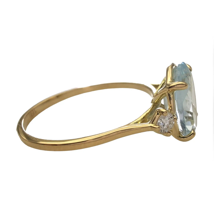 Right horizontal side view of a buyable 18K yellow gold engagement ring with a central oval aquamarine and diamonds, showcasing exquisite craftsmanship