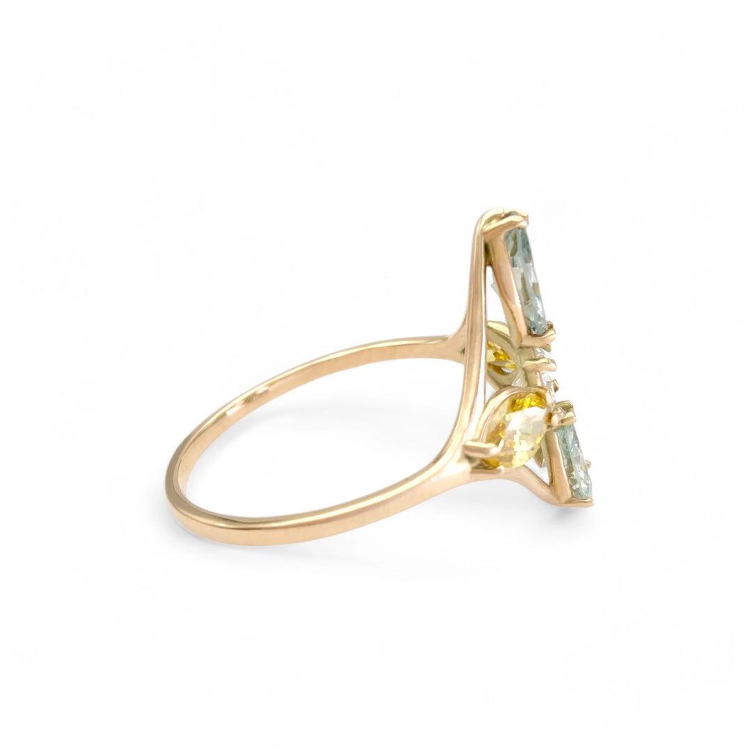 Right side view of a 14K yellow gold engagement ring with fancy colored marquise diamonds complementing a central brilliant-cut diamond, showcasing the ring's luxurious and colorful design.