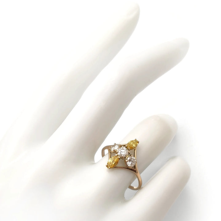 14K yellow gold engagement ring on a mannequin hand featuring a unique cross design of brilliant and marquise diamonds, perfect to buy for a special proposal.