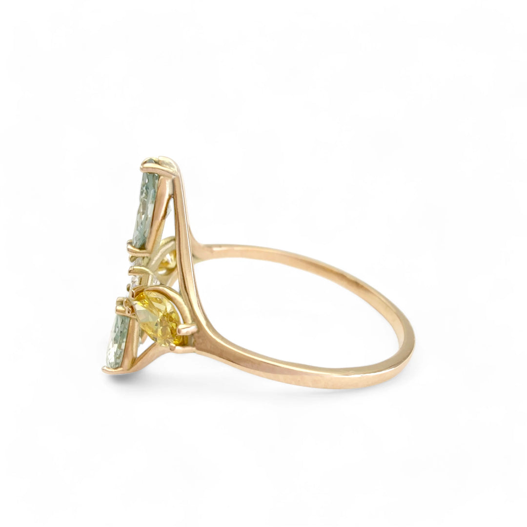 Left side view of a 14K yellow gold engagement ring showing the arrangement of blue and yellow marquise diamonds around a central brilliant-cut diamond